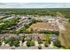An aerial view captures homes in a neighborhood with trees and an open lot at 528 Seven Oaks Blvd, Winter Springs, FL 32708