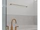 Close-up of bath with elegant gold fixtures and neutral tiling at 528 Seven Oaks Blvd, Winter Springs, FL 32708