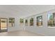 An airy sunroom featuring neutral carpeting, white walls, and several windows overlooking the backyard at 528 Seven Oaks Blvd, Winter Springs, FL 32708