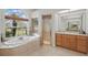 Bright bathroom with a garden tub, walk-in shower, and a view of the outdoors at 6758 Hillis Dr, Lakeland, FL 33813