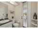 Stylish half bathroom with a decorative mirror and a view of the pool at 6758 Hillis Dr, Lakeland, FL 33813