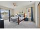 This bedroom features a bed with a striped comforter, dark wood furniture, and natural light at 6758 Hillis Dr, Lakeland, FL 33813