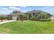 Charming single-story home with a large lawn, palm trees, and a two-car garage at 6758 Hillis Dr, Lakeland, FL 33813