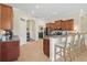 This kitchen features stainless appliances, wood cabinets, granite counters, tile floors, and bar seating at 6758 Hillis Dr, Lakeland, FL 33813