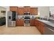 The kitchen features stainless steel appliances, wooden cabinets, granite counters, and tile floors at 6758 Hillis Dr, Lakeland, FL 33813