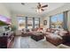 This living room is furnished with a leather sectional couch, ottoman, area rug, and large windows at 6758 Hillis Dr, Lakeland, FL 33813