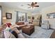 Spacious living room with a leather sectional couch, an area rug, large windows and an open floor plan at 6758 Hillis Dr, Lakeland, FL 33813