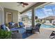 Relaxing covered patio seating area with wicker furniture overlooking a sparkling swimming pool and screened enclosure at 6758 Hillis Dr, Lakeland, FL 33813