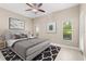 This staged bedroom features neutral colors, three windows, and coordinated wall decor and bedding at 676 Sandy Neck Ln # 102, Altamonte Springs, FL 32714