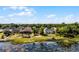 Aerial view of homes, lake, mature trees, and lush landscaping in a residential neighborhood at 724 Wildmere Village Cv, Longwood, FL 32750