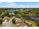 Aerial view of a serene neighborhood with houses nestled around a lake and mature trees at 724 Wildmere Village Cv, Longwood, FL 32750