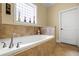 Bathroom featuring a soaking tub with tile surround and a frosted glass window at 724 Wildmere Village Cv, Longwood, FL 32750