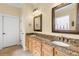 Bathroom featuring double vanity with granite countertop, framed mirrors, and tile flooring at 724 Wildmere Village Cv, Longwood, FL 32750