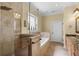 Tiled bathroom featuring glass-enclosed shower, soaking tub, and double vanity at 724 Wildmere Village Cv, Longwood, FL 32750