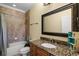 Well-appointed bathroom with tiled walls, shower-tub combo, granite vanity, and decorative mirror at 724 Wildmere Village Cv, Longwood, FL 32750