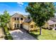 Attractive two-story home featuring a well-manicured lawn, charming shutters, and a brick driveway at 724 Wildmere Village Cv, Longwood, FL 32750