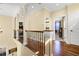 This hallway is bright and spacious, features wood flooring, and iron decorative railings at 724 Wildmere Village Cv, Longwood, FL 32750