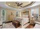Main bedroom featuring a four-poster bed, ceiling fan, hardwood floors and a sitting area at 724 Wildmere Village Cv, Longwood, FL 32750