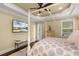 Main bedroom with a four-poster bed, tray ceiling, TV, hardwood floors, and access to the exterior at 724 Wildmere Village Cv, Longwood, FL 32750