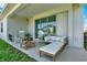 A covered back patio with comfortable seating and view through sliding glass doors at 765 Terrapin Dr, Debary, FL 32713