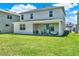 Spacious backyard with lush green grass and a covered patio featuring comfortable seating at 765 Terrapin Dr, Debary, FL 32713