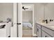 Bathroom featuring double sinks, quartz countertop, modern fixtures, and open bedroom view at 765 Terrapin Dr, Debary, FL 32713