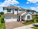 Two-story home with a two-car garage, brick driveway, manicured lawn, and stone veneer accents at 765 Terrapin Dr, Debary, FL 32713