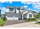 Charming two-story home with a two-car garage, brick driveway, manicured lawn, and stone veneer accents at 765 Terrapin Dr, Debary, FL 32713