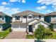 Two-story home featuring a two-car garage, brick driveway, blue shutters, and a well-manicured lawn at 765 Terrapin Dr, Debary, FL 32713