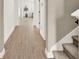 Inviting hallway featuring modern wood-look flooring and stairs leading to the upper level at 765 Terrapin Dr, Debary, FL 32713