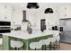 Bright, modern kitchen with white cabinets, stainless appliances, and a large green island with white bar stools at 765 Terrapin Dr, Debary, FL 32713