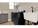 Well-lit laundry room featuring a utility sink, storage, modern appliances, and wire rack shelving at 765 Terrapin Dr, Debary, FL 32713