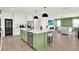 Open-concept living space featuring a kitchen island and a comfortable living room with a stylish green accent wall at 765 Terrapin Dr, Debary, FL 32713