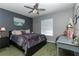 Comfortable bedroom with dark wall paint, ceiling fan, window with blinds, and work area at 821 N Lake Claire Cir, Oviedo, FL 32765