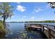 Scenic view of a wooden dock extending into a tranquil lake with lily pads and a clear sky at 821 N Lake Claire Cir, Oviedo, FL 32765