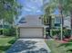 Charming two-story home featuring an attached garage, lush landscaping, and a welcoming entryway at 821 N Lake Claire Cir, Oviedo, FL 32765