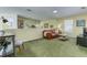 View of the living room featuring green carpeting and a brown leather sofa at 821 N Lake Claire Cir, Oviedo, FL 32765
