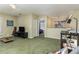 Open-concept living room showcases green carpets, TV, and a view into bedroom at 821 N Lake Claire Cir, Oviedo, FL 32765