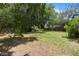 Green backyard with mature trees and a wooden fence at 825 Mellowood Ave, Orlando, FL 32825