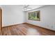 Bedroom featuring hardwood floors, a ceiling fan, and a window overlooking trees at 825 Mellowood Ave, Orlando, FL 32825