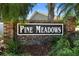 Attractive brick community sign reading 'Pine Meadows' surrounded by lush greenery at 825 Mellowood Ave, Orlando, FL 32825