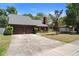 Inviting home with a spacious driveway, mature trees, and classic architecture at 825 Mellowood Ave, Orlando, FL 32825