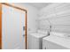 Laundry room with washer, dryer, wire shelving, and a secure keyless entry door at 825 Mellowood Ave, Orlando, FL 32825