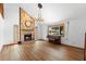 Bright living room featuring a stone fireplace, large window, and wood-look floors at 825 Mellowood Ave, Orlando, FL 32825