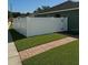 Long white fence in the backyard of the property with manicured lawn at 8325 Sun Vista Way, Orlando, FL 32822