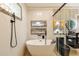 This modern bathroom features a stand-alone tub, stylish tile, and decorative shelving for a spa-like experience at 8325 Sun Vista Way, Orlando, FL 32822
