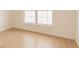 Bright bedroom with light wood floors, a large double window, and a clean, minimalist design at 8325 Sun Vista Way, Orlando, FL 32822