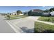 Landscaped front yard with a well-maintained lawn, decorative trees, and a concrete driveway leading to the garage at 8325 Sun Vista Way, Orlando, FL 32822