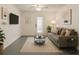 Comfortable living room featuring a sofa, a modern rug, neutral decor, and natural light at 8325 Sun Vista Way, Orlando, FL 32822