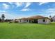 View of the backyard with a large, well-maintained lawn and covered patio at 8509 Sw 136Th Loop, Ocala, FL 34473